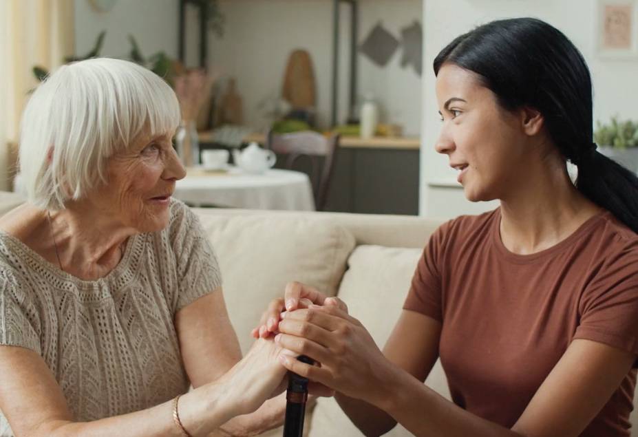 elderly woman talks to younger woman