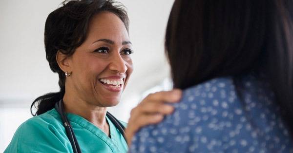 healthcare professional touches the shoulder of a patient