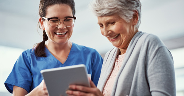medical professional shows elderly patient information on a mobile tablet