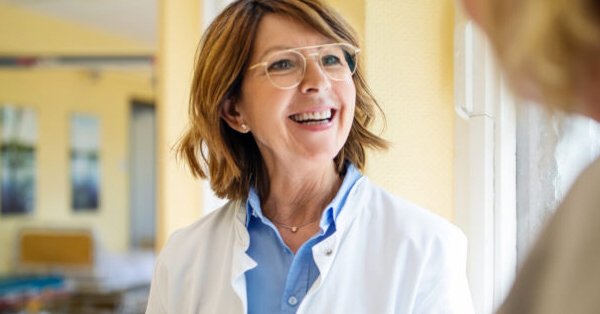 Healthcare professional in lab coat wearing glasses