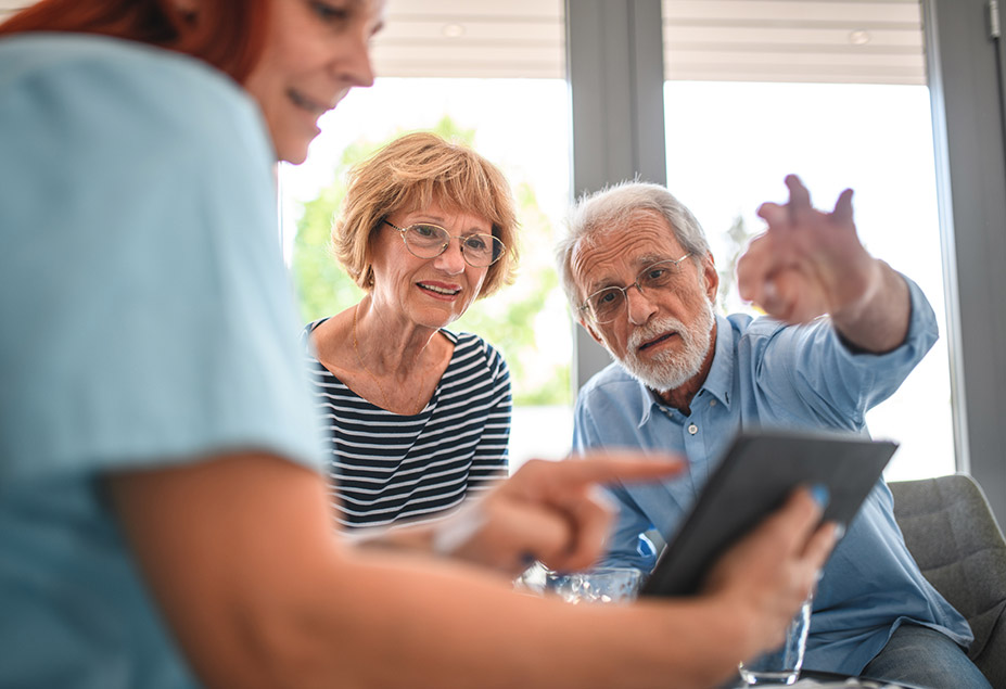 healthcare professional shows elderly people information on a tablet