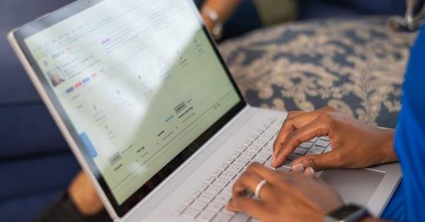 hands of healthcare professional typing on laptop