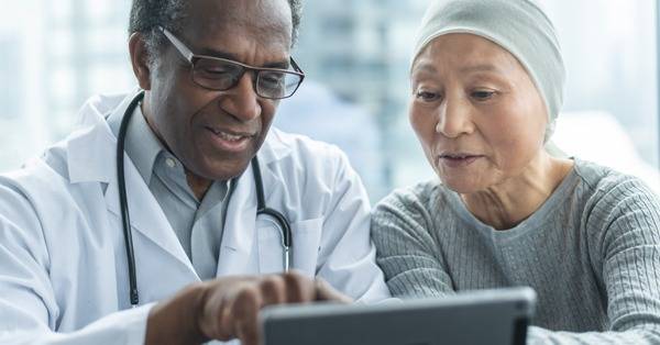 BIPOC healthcare professional shows BIPOC patient information on a mobile tablet