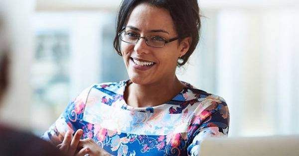 woman smiles in front of computer