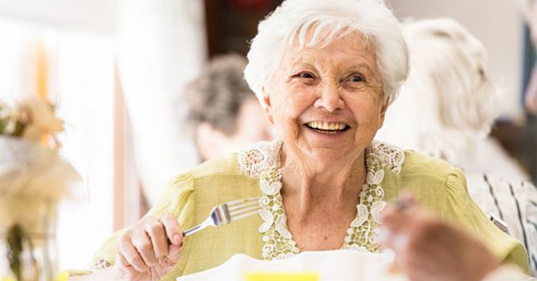 elderly woman holds fork