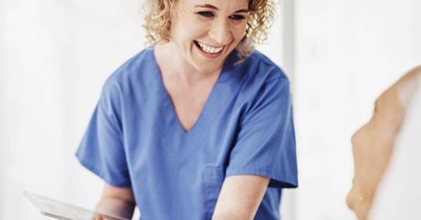 Healthcare professional smiles at elderly patient
