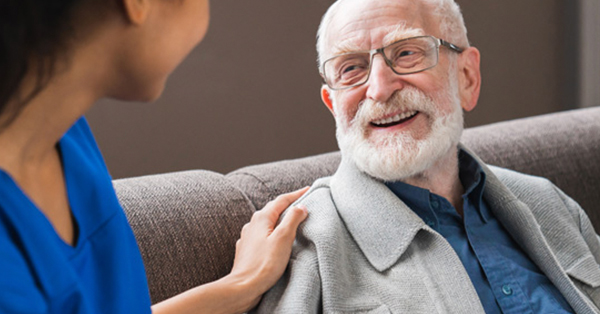 Elderly patient smiles at healthcare provider