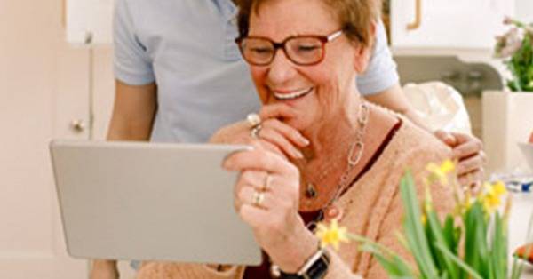 Elderly woman looks at tablet