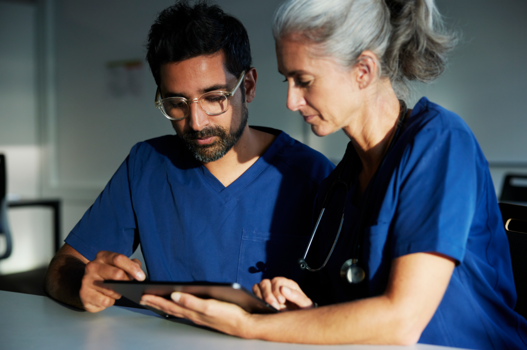 two health care professionals look at tablet