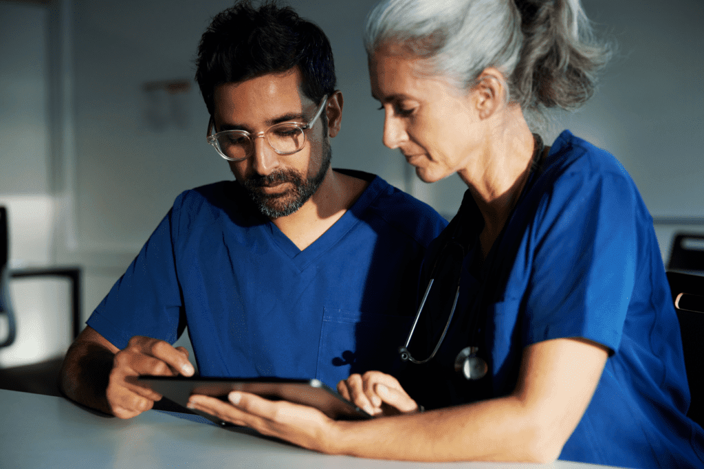 two health care professionals look at tablet