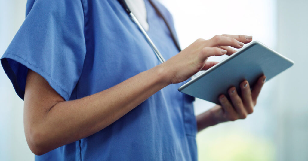 healthcare professional works on tablet