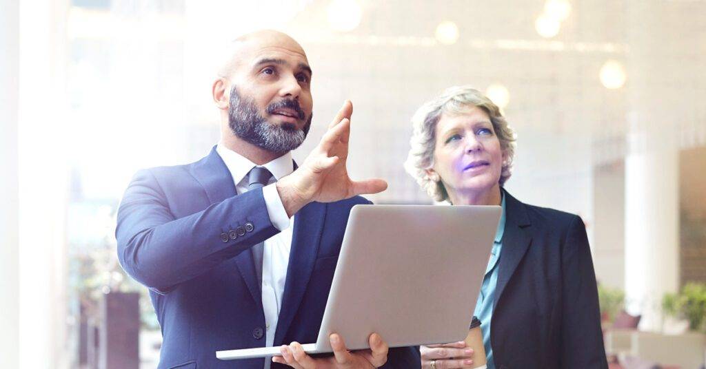 healthcare professionals talk in front of a laptop