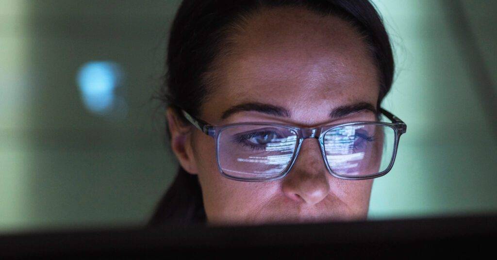 woman looks at computer screen