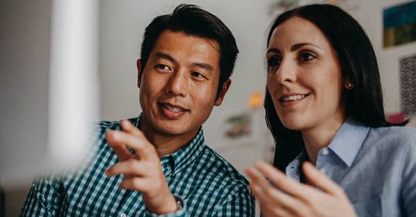 man and woman reviewing data on monitor