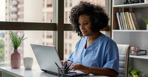 Medical professional reviewing data on laptop