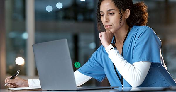 healthcare professional looks at laptop