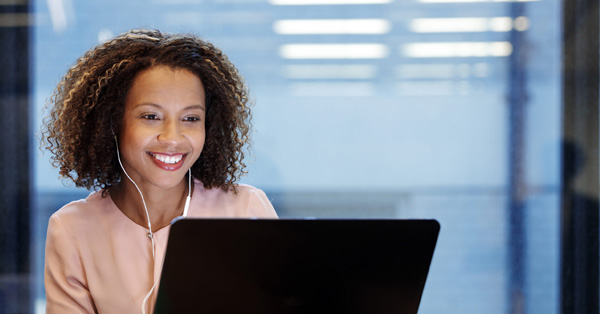 Beautiful woman smiling at computer screen