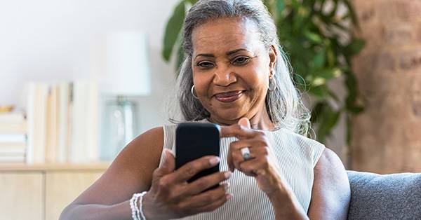 elderly woman texts on mobile device