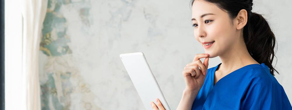 Female health professional reviewing data on tablet device